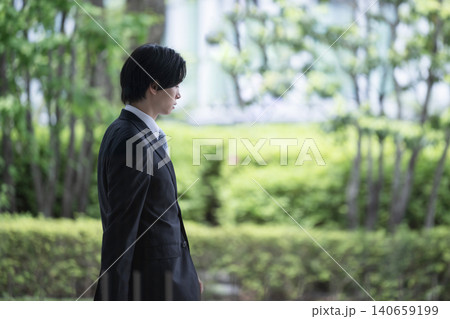 将来や転職を考える若手ビジネスマン 会社で歩く落ち込む様子 将来や転職を考える若手ビジネスマン 会社で歩く落ち込む様子 140659199