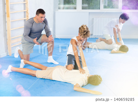 Diligent preteen student twisting his opponent's arm on the floor Diligent preteen student twisting his opponent's arm on the floor 140659285
