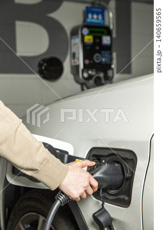 Charging an electric vehicle at a charging station Charging an electric vehicle at a charging station 140659565