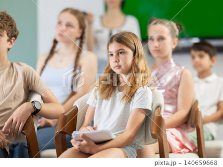 During lecture meeting at class, teens and preteens pupil listen to female teacher 140659668