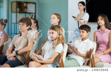 During lecture meeting at class, teens and preteens pupil listen to female teacher 140659848
