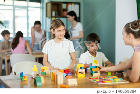 Children sit at table and play with toys Children sit at table and play with toys 140659884