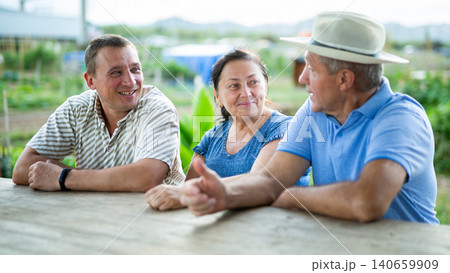 Happy farmers talking at village table 140659909