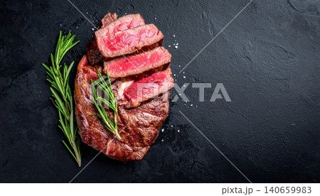 Steak with rosemary on a black background. Top view Steak with rosemary on a black background. Top view 140659983