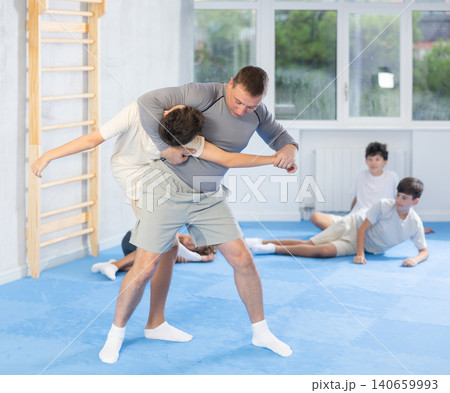 Judo teenager kids and trainer engaged in judo class in dojo at gym 140659993