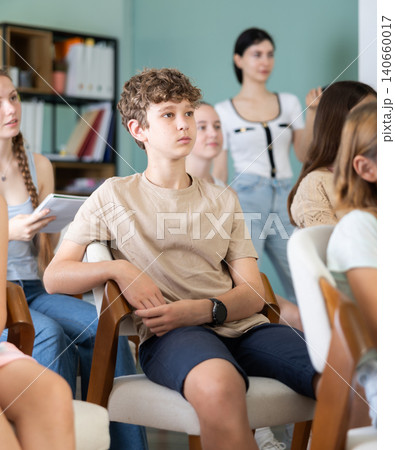 During lecture meeting at class, teens and preteens pupil listen to female teacher During lecture meeting at class, teens and preteens pupil listen to female teacher 140660017