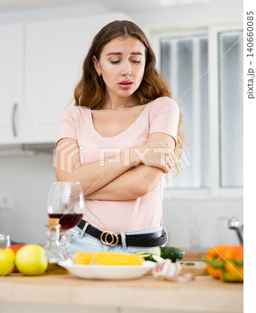 Portrait of a frustrated young woman in the kitchen Portrait of a frustrated young woman in the kitchen 140660085
