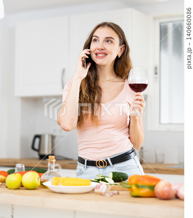 Positive young woman communicates with someone on a mobile phone Positive young woman communicates with someone on a mobile phone 140660086