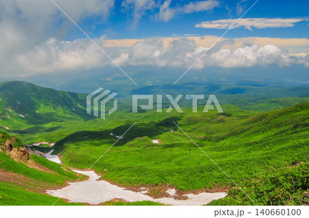 梅雨明けの晴天 青空と湧き上がる雲にそびえる鳥海山の緑の山肌と残雪風景 梅雨明けの晴天 青空と湧き上がる雲にそびえる鳥海山の緑の山肌と残雪風景 140660100
