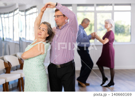 Middle-aged man and elderly woman are dancing classic version of waltz in couple. 140660169