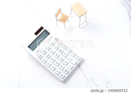 高騰する教育費 - 学校の机と椅子、電卓がイメージする、高騰を続けて家計を圧迫する教育費のイメージ 高騰する教育費 - 学校の机と椅子、電卓がイメージする、高騰を続けて家計を圧迫する教育費のイメージ 140660552