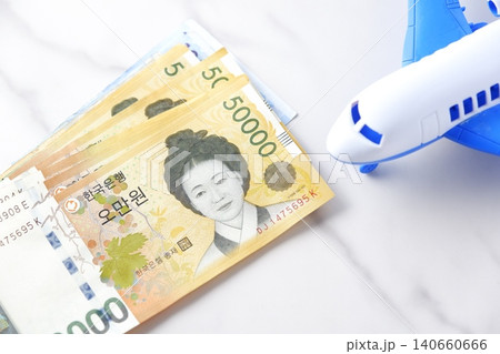 韓国の通貨、ウォンKRWの紙幣と飛行機で、韓国旅行に出発するイメージ 140660666