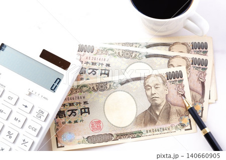 一万円紙幣と電卓 - テーブルの上に置かれた10000円札の紙幣と電卓 一万円紙幣と電卓 - テーブルの上に置かれた10000円札の紙幣と電卓 140660905