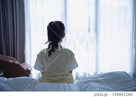 Child Sitting on Bed Looking Out Window in Cozy Bedroom with Natural Light, Calm Atmosphere, and Comfortable Environment, Indoor Residential Scene Child Sitting on Bed Looking Out Window in Cozy Bedroom with Natural Light, Calm Atmosphere, and Comfortable Environment, Indoor Residential Scene 140661266