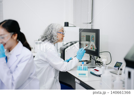 Team of scientists analyzing blue liquid samples in a modern lab, showcasing biotechnology, chemistry, and medical research Team of scientists analyzing blue liquid samples in a modern lab, showcasing biotechnology, chemistry, and medical research 140661366