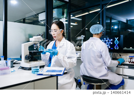 Team of scientists analyzing blue liquid samples in a modern lab, showcasing biotechnology, chemistry, and medical research innovation. Team of scientists analyzing blue liquid samples in a modern lab, showcasing biotechnology, chemistry, and medical research innovation. 140661414