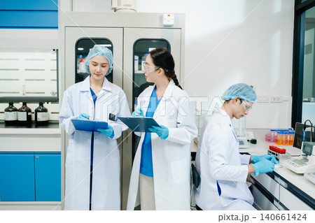 Team scientist or medical technician working, having a medical discuss meeting with an Asian senior female scientist supervisor 140661424