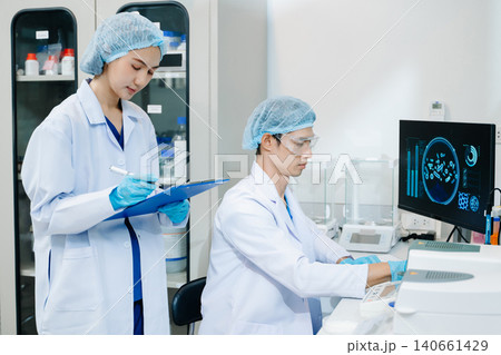 Team scientist or medical technician working, having a medical discuss meeting with an Asian senior female scientist supervisor 140661429