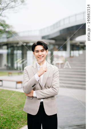 Confident Asian businessman giving thumbs up outside modern office building, success, approval, leadership, startup growth Confident Asian businessman giving thumbs up outside modern office building, success, approval, leadership, startup growth 140661514