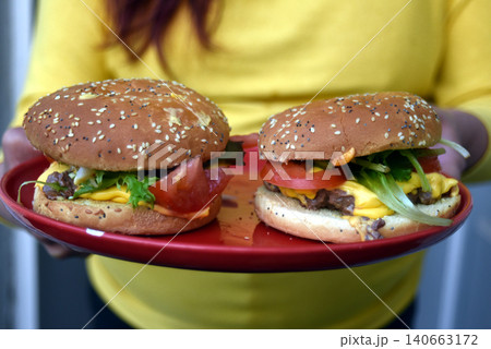 closeup of homemade hamburger in hands of woman closeup of homemade hamburger in hands of woman 140663172