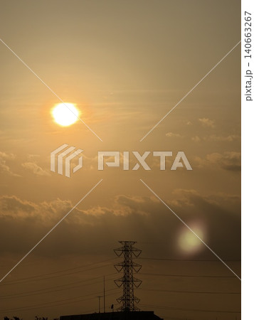 夕日に照らされる鉄塔と黄金色の空 140663267