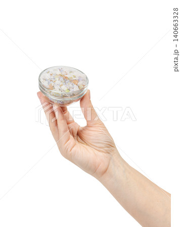 Woman's hand holing a glass bowl with sea bath salt. 140663328