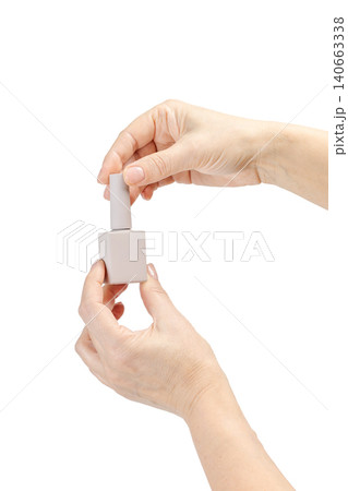 Woman holding a bottle with nail polish on the white background. Woman holding a bottle with nail polish on the white background. 140663338