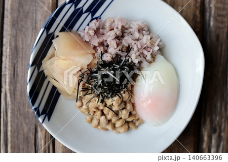 温玉と新生姜の甘酢漬けをトッピングした十六穀米の納豆ごはん 140663396