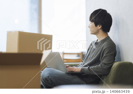 段ボール箱に囲まれて座る若い男性 引っ越し イメージ 段ボール箱に囲まれて座る若い男性 引っ越し イメージ 140663439
