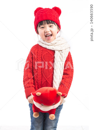Smiling little girl hugging a red ox plush toy, celebrating the Year of the Ox, Chinese New Year theme. 140663590