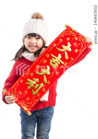 Happy little girl holding a red scroll with "Da Ji Da Li" (Good luck and prosperity) for Lunar New Year. 140663602