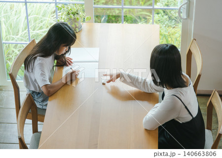 宿題をする女の子と見守る母親 宿題をする女の子と見守る母親 140663806