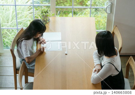 宿題をする女の子と見守る母親 宿題をする女の子と見守る母親 140663808