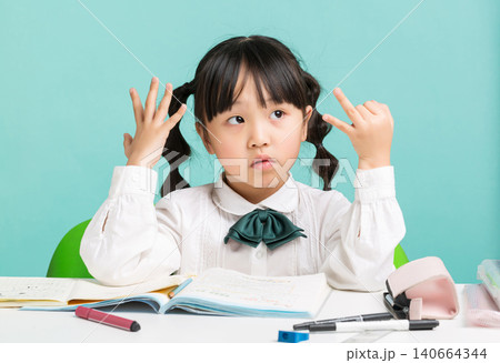 Asian schoolgirl counting on fingers while studying at desk, thinking and math learning concept, education and problem solving Asian schoolgirl counting on fingers while studying at desk, thinking and math learning concept, education and problem solving 140664344