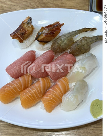 An assortment of fresh sushi, artfully arranged with a variety of toppings and vibrant colors. This traditional Japanese dish combines vinegared rice, seafood, and vegetables for an experience. 140664577