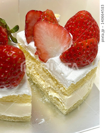 Strawberry cake with soft fluffy layers, topped with fresh strawberries and smooth cream, showcasing vibrant red fruit, delicate textures, and sweet inviting appearance in close-up detail 140664583