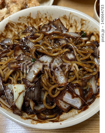 Classic jajangmyeon with thick noodles in a rich black bean sauce, garnished with sliced cucumber and sesame seeds. A beloved Korean-Chinese comfort dish, full of savory depth and flavor. 140664783