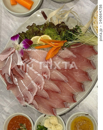 Fresh and delicate sashimi slices, beautifully presented with vibrant colors and perfect cuts. This traditional Japanese delicacy highlights the pure flavors of premium seafood. 140664786