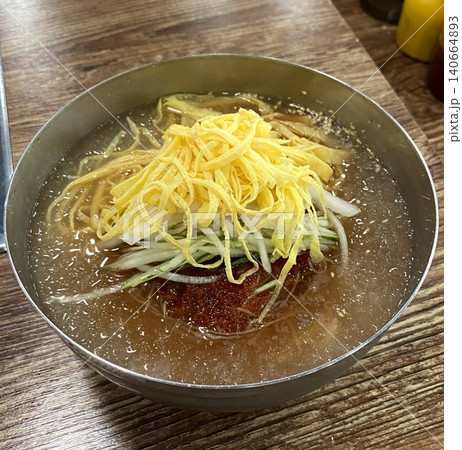 Authentic Pyongyang naengmyeon with chewy buckwheat noodles in cold, clear broth, offering a refreshing and delicate flavor. Perfect for traditional Korean cuisine menus and summer dishes. 140664893