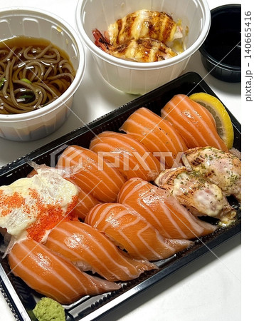 Fresh salmon sushi with bright orange slices placed on top of perfectly shaped rice, garnished with green leaves and radish for a simple, colorful, and appetizing presentation Fresh salmon sushi with bright orange slices placed on top of perfectly shaped rice, garnished with green leaves and radish for a simple, colorful, and appetizing presentation 140665416