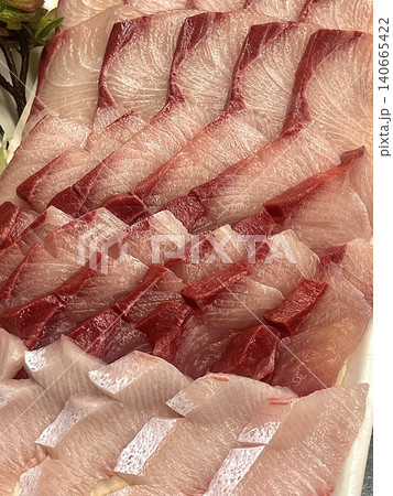 Fresh and delicate sashimi slices, beautifully presented with vibrant colors and perfect cuts. This traditional Japanese delicacy highlights the pure flavors of premium seafood. 140665422