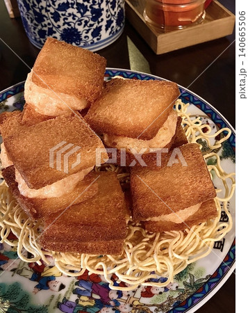 Menbosha shrimp toast with golden crispy bread enclosing tender shrimp filling, highlighting crunchy texture, juicy interior, and rich golden-brown color in close-up appetizing detail 140665506