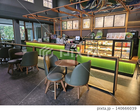Modern coffee shop interior featuring a vibrant illuminated green service counter, stylish wooden bar. Modern coffee shop interior featuring a vibrant illuminated green service counter, stylish wooden bar. 140666039