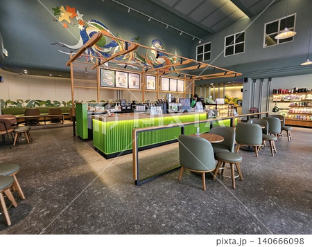Modern coffee shop interior featuring a vibrant illuminated green service counter, stylish wooden bar. Modern coffee shop interior featuring a vibrant illuminated green service counter, stylish wooden bar. 140666098