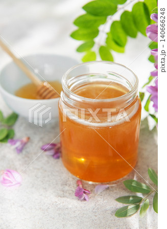 Acacia honey jar with dipper and blossoms Acacia honey jar with dipper and blossoms 140666248
