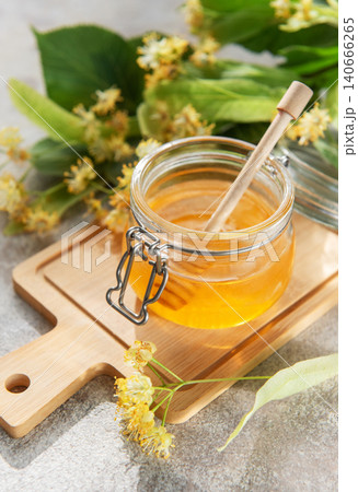 Fresh linden honey in a glass jar with dipper Fresh linden honey in a glass jar with dipper 140666265