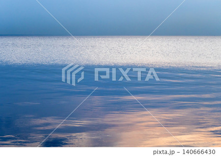Serene blue ocean horizon with gentle ripples and soft sunset Serene blue ocean horizon with gentle ripples and soft sunset 140666430
