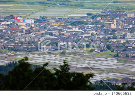 西南戦争の激戦地・高熊山から望遠で望む、田植え時期の伊佐市盆地の水田と街並み 140666652