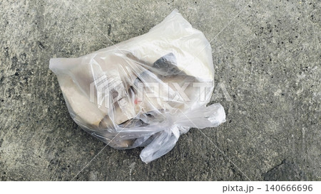 Plastic bag filled with garbage abandoned on dirty soil ground. Plastic bag filled with garbage abandoned on dirty soil ground. 140666696