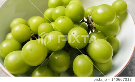 Fresh green Shine Muscat grapes bunch in a white bowl Fresh green Shine Muscat grapes bunch in a white bowl 140667038
